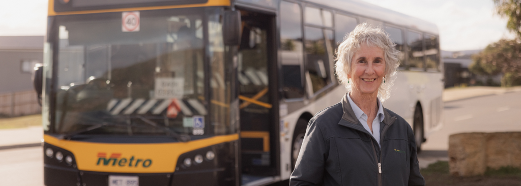 Female bus driver in front of bus