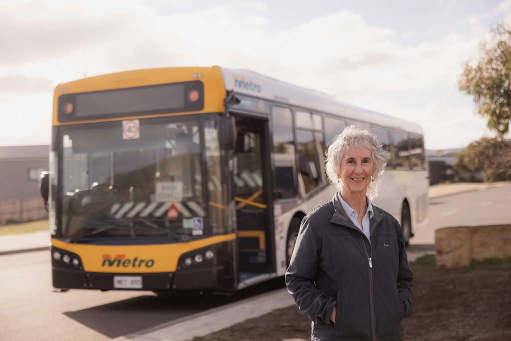 Female bus driver smiles in front of Metro bus